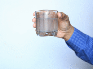 Homeowner holding up glass of dirty water