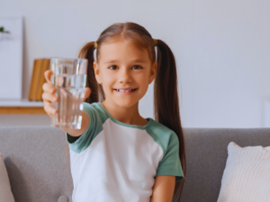 Young girl holding glass of clean water