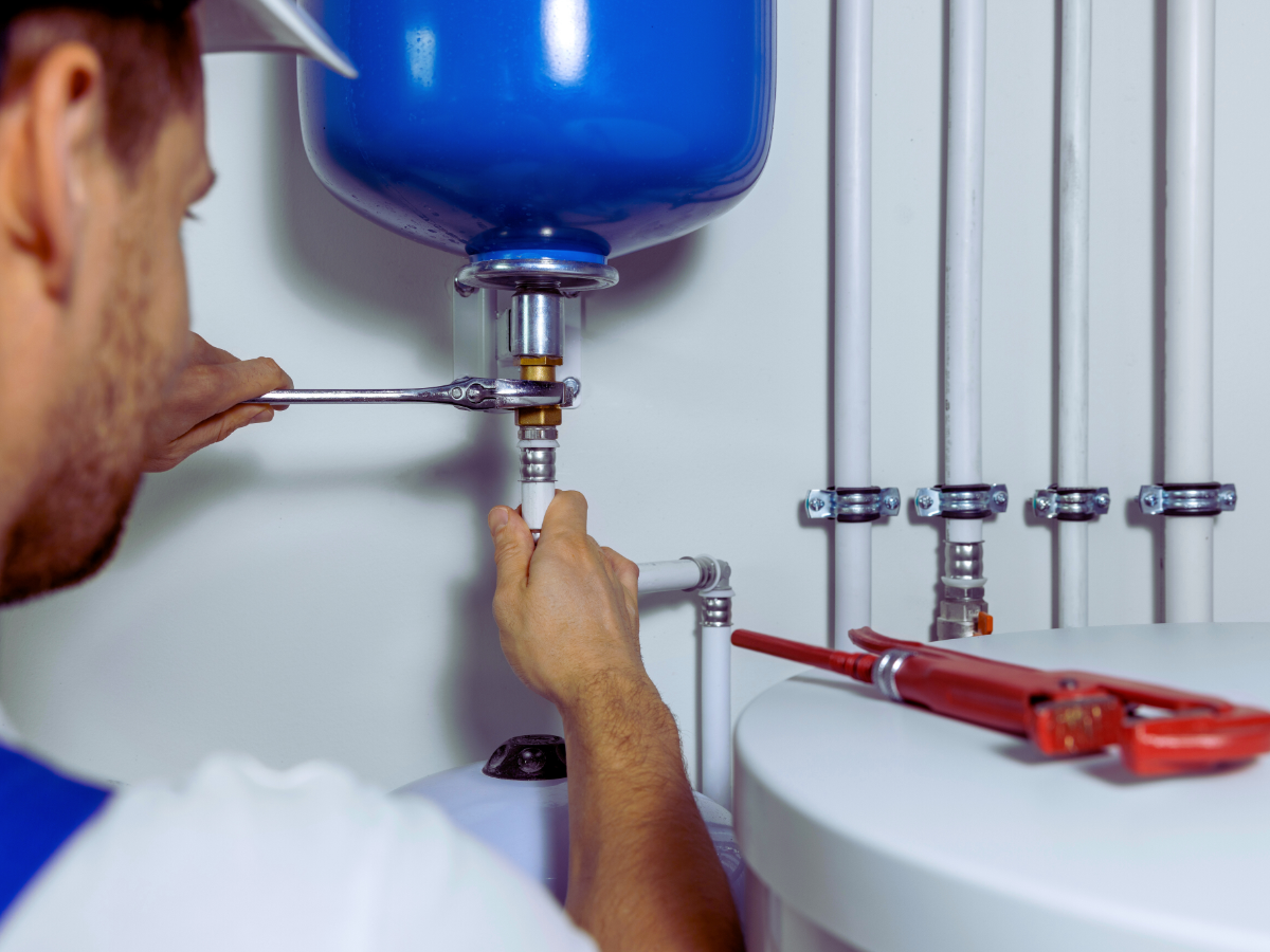 plumber installing an expansion tank on water heater